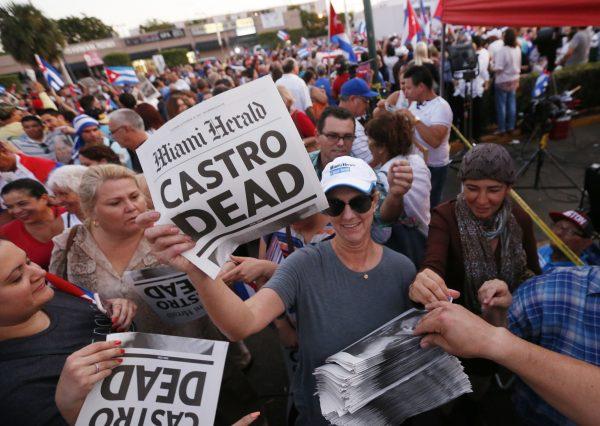 Alexandra Villoch, president and publisher of the Miami Herald Media Co., hands out a special edition of the Miami Herald with the headline "Castro Dead," in front of the Versailles Restaurant in the Little Havana neighborhood of Miami, on Nov. 26, 2016. (AP Photo/Wilfredo Lee)