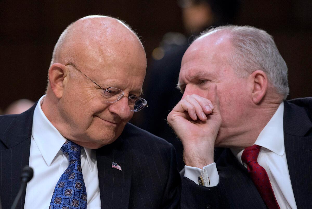 Then-Director of National Intelligence James Clapper (L) and then-CIA Director John Brennan chat before testifying before the Senate Intelligence Committee on Feb. 9, 2016. (Molly Riley/AFP/Getty Images)