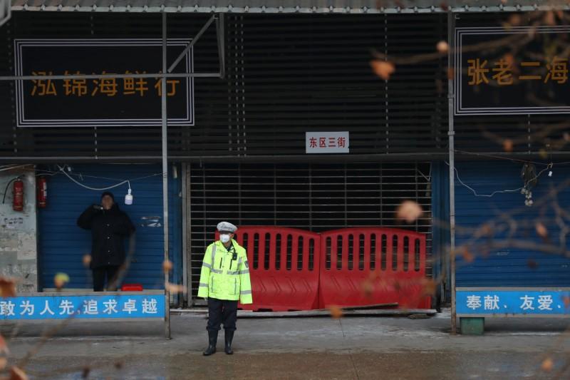 A police officer wearing a mask stands in front of the closed seafood market in Wuhan, Hubei province, China on Jan. 10, 2020. (Stringer/Reuters)