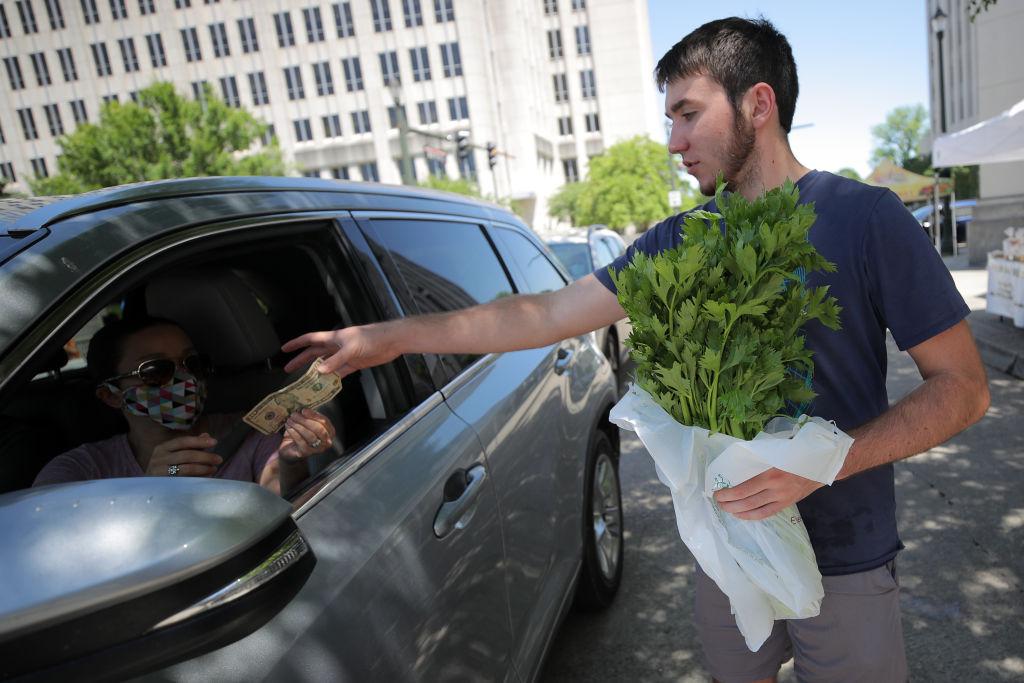 A person buys produce at a drive-through farmer's market in Baton Rouge, La. on April 25, 2020. Due to the threat of COVID-19, the farmers market has adapted to a drive-through format to minimize contact. (Chris Graythen/Getty Images)