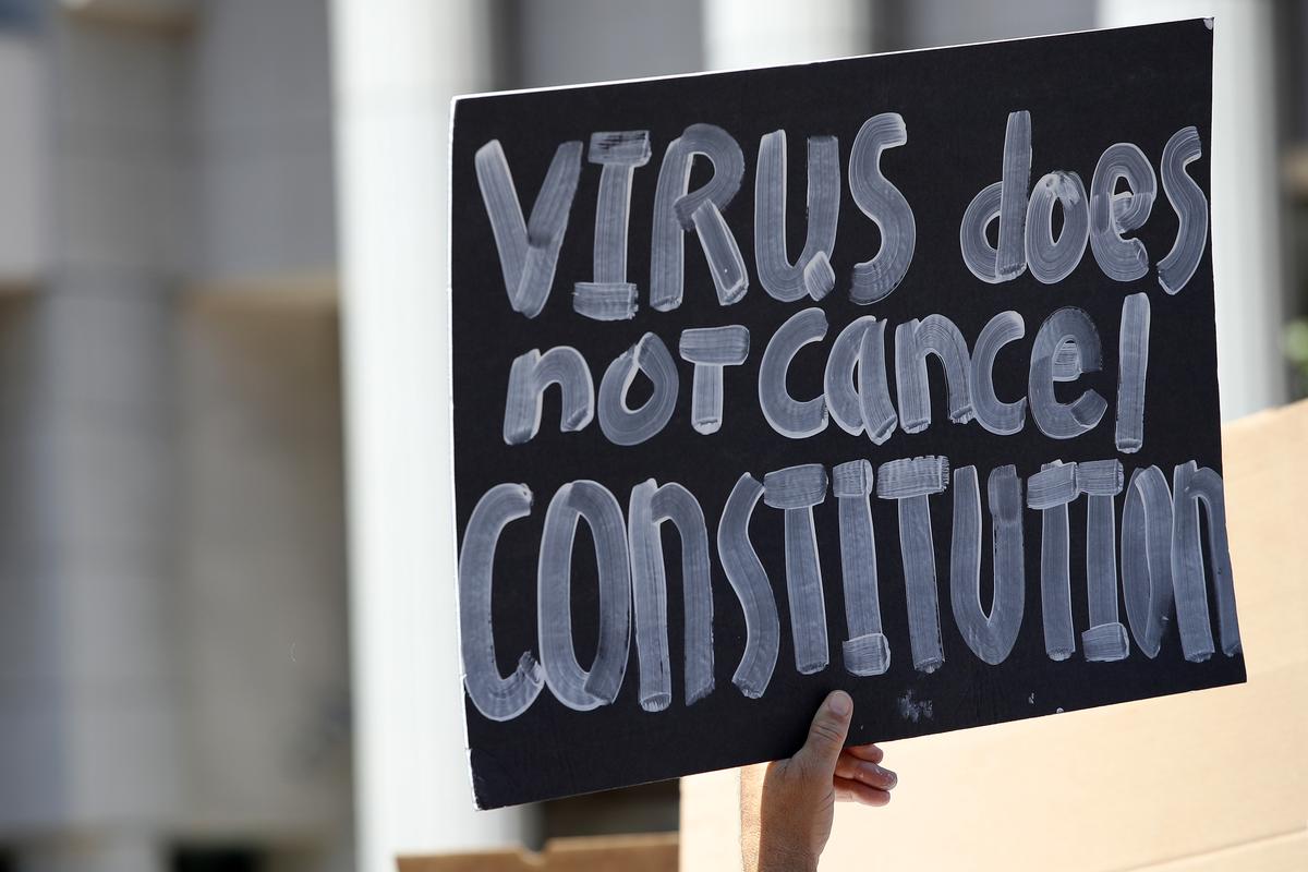 Activists hold signs and protest the California lockdown due to the CCP (Chinese Communist Party) virus pandemic, in San Diego, Calif. on May 1, 2020. The protesters' demands included opening small businesses, churches, as well as support for President Trump. (Sean M. Haffey/Getty Images)
