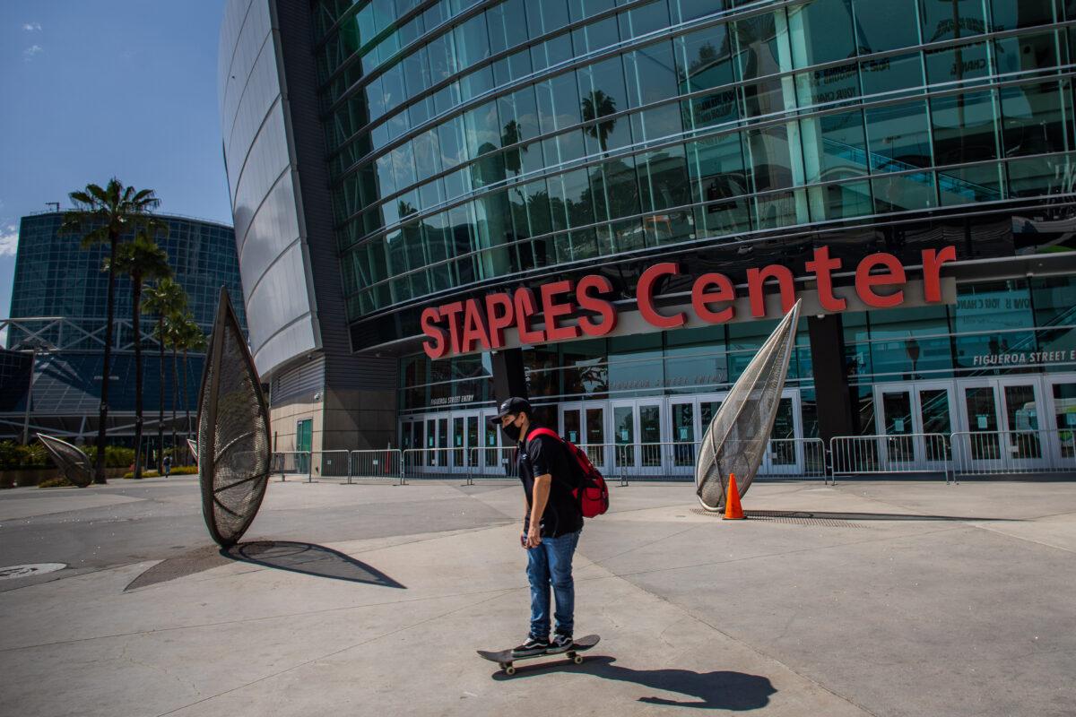 A man wearing a mask skates in front of the Staples Center in downtown Los Angeles, Calif., on May 9, 2020. (Apu Gomes/AFP via Getty Images)
