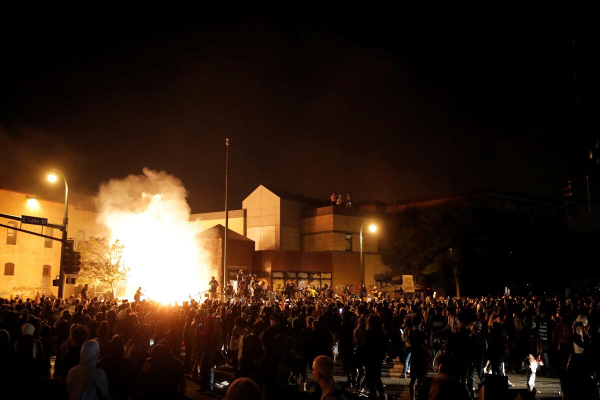 Protesters gather around after setting fire to the entrance of a police station in Minneapolis, Minn., early on May 29, 2020. (Carlos Barria/Reuters)