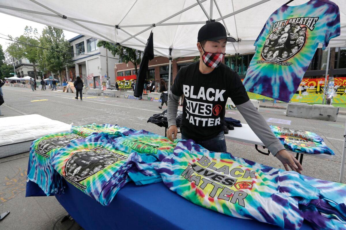 T-shirt vendor Gavin Chung sets-up in view of a closed Seattle police precinct in Seattle on June 28, 2020. (Elaine Thompson/AP Photo)