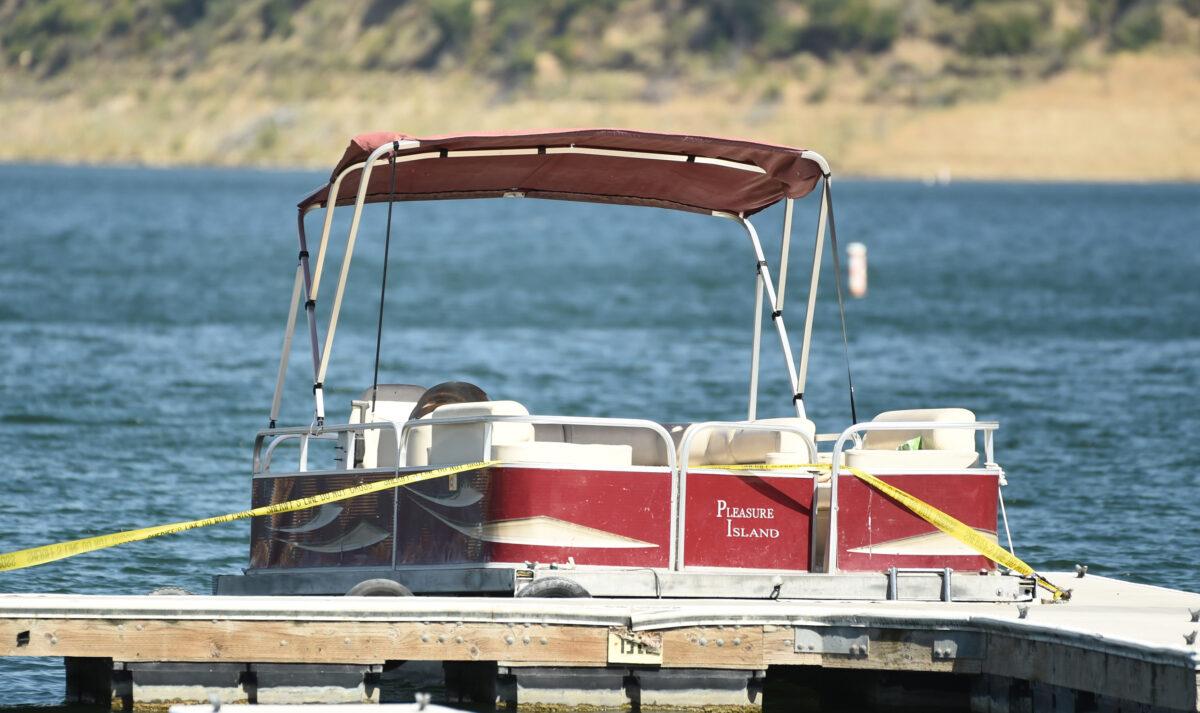 A boat covered in caution tape rented by "Glee" actress Naya Rivera sits at a dock while members of Ventura County Sheriff's Office Underwater Search and Rescue Team search for the actress at Lake Piru in Los Padres National Forest, northwest of Los Angeles, Calif., on July 9, 2020. (Chris Pizzello/AP Photo)