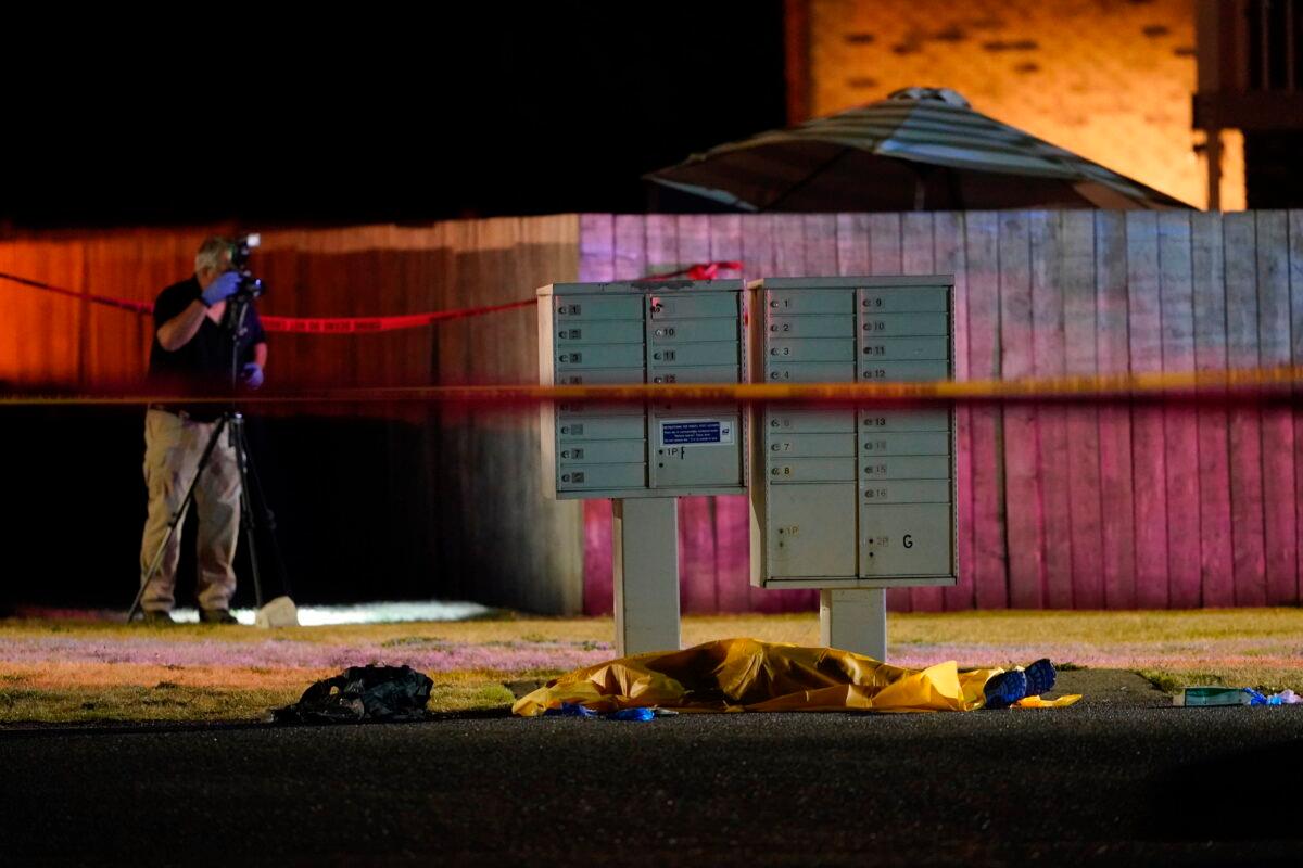 Officials work at a scene where a man suspected of gunning down another man in Portland, Ore., over the weekend, was killed by investigators in Lacey, Wash., late Sept. 3, 2020. (Ted Warren/AP Photo)