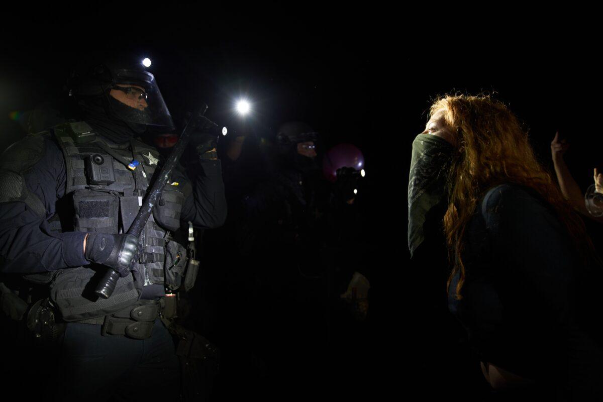 A woman yells at Oregon State Police troopers in Portland, Ore., on Sept. 4, 2020. (Nathan Howard/Getty Images)