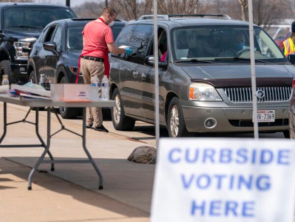 A poll worker talks to people during curbside voting in Sun Prarie, Wis., on April 7, 2020. (Andy Manis/Getty Images)