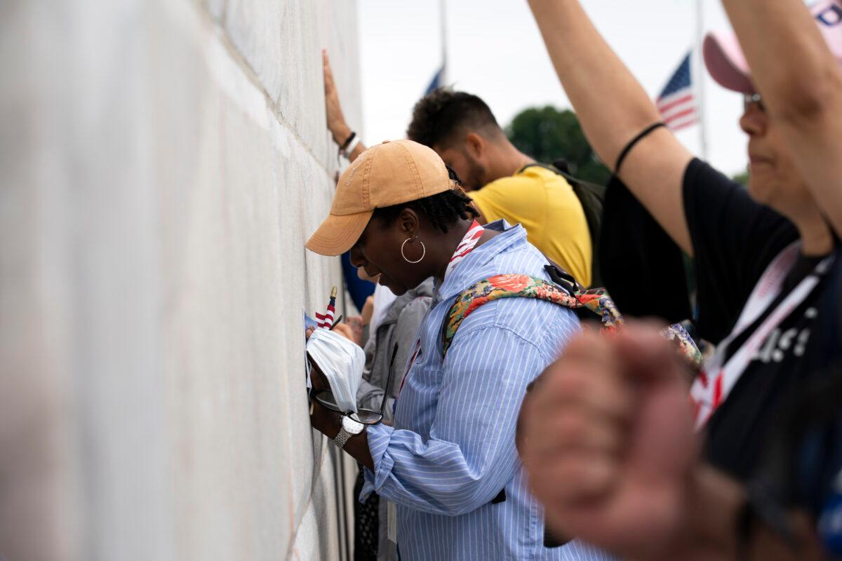 People pray at the base of the Washington Monument as they march from the Lincoln Memorial to Capitol Hill, during the Prayer March at the National Mall, in Washington on Sept. 26, 2020. (Jose Luis Magana/AP Photo)