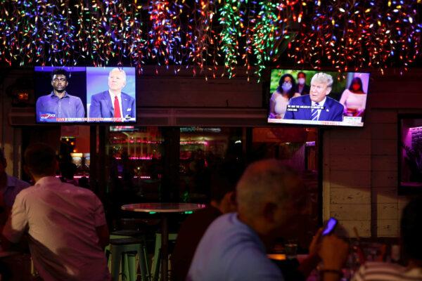 The dual town halls of Democratic presidential candidate Joe Biden and President Donald Trump, are seen on television monitors at Luv Child restaurant ahead of the election in Tampa, Florida, on Oct. 15, 2020. (Octavio Jones/Reuters)