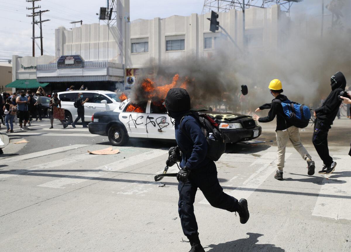 A Los Angeles Police Department vehicle is set on fire by rioters in Los Angeles on May 30, 2020. (Mario Tama/Getty Images)