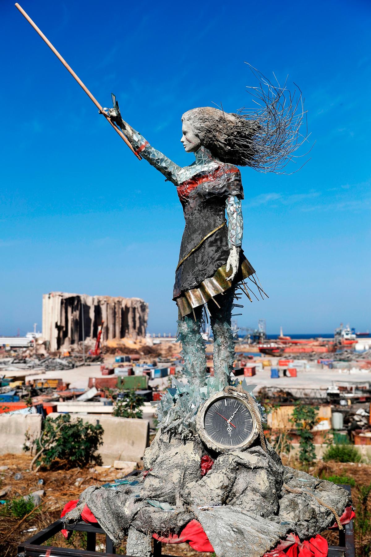 A statue of a woman by Lebanese artist Hayat Nazer, made out of leftover glass, rubble, and a broken clock marking the time (6:08 PM) of the mega explosion at the port of Beirut (JOSEPH EID/AFP via Getty Images)