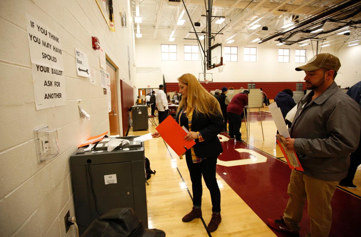 A woman places her ballot in the tabulation machine after voting at Western High School during the presidential primary election in Warren, Mich., on March 10, 2020. (Jeff Kowalsky/AFP via Getty Images)