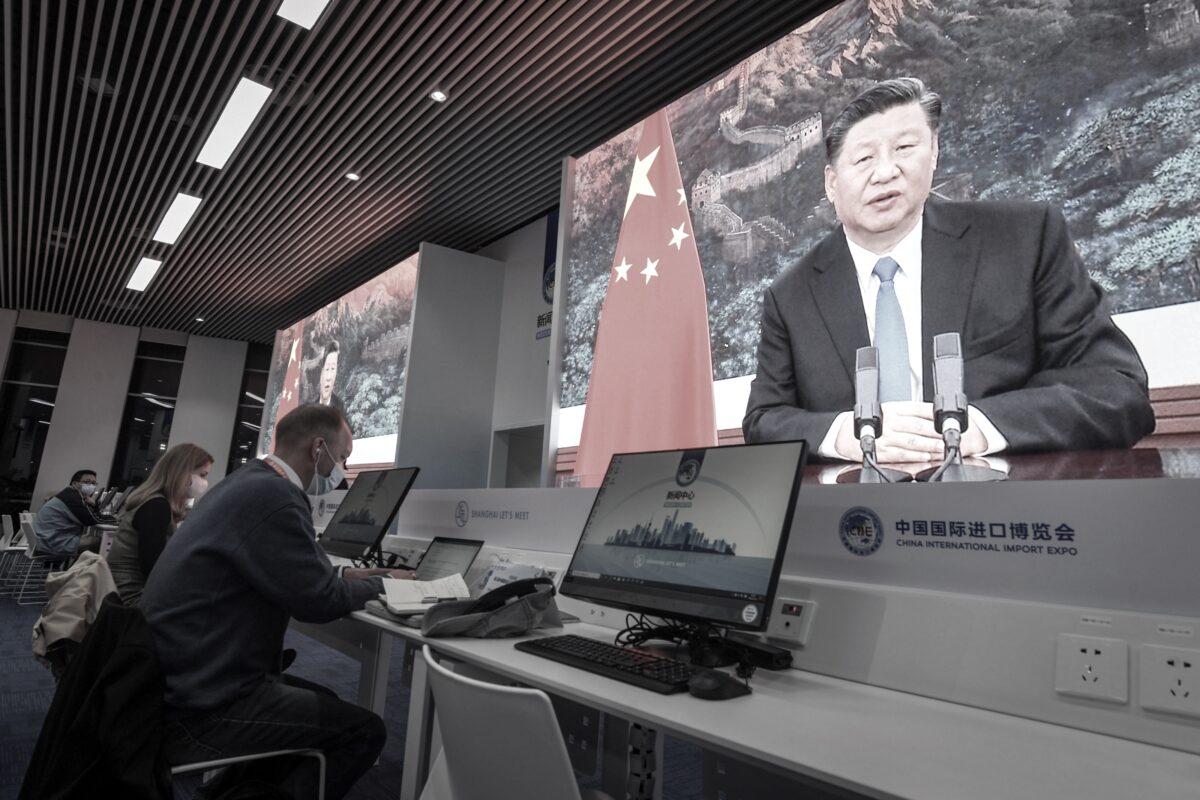 Journalists sit next to the screens showing Chinese Leader Xi Jinping delivering a speech via video on Nov. 4, 2020. (STR/AFP via Getty Images)
