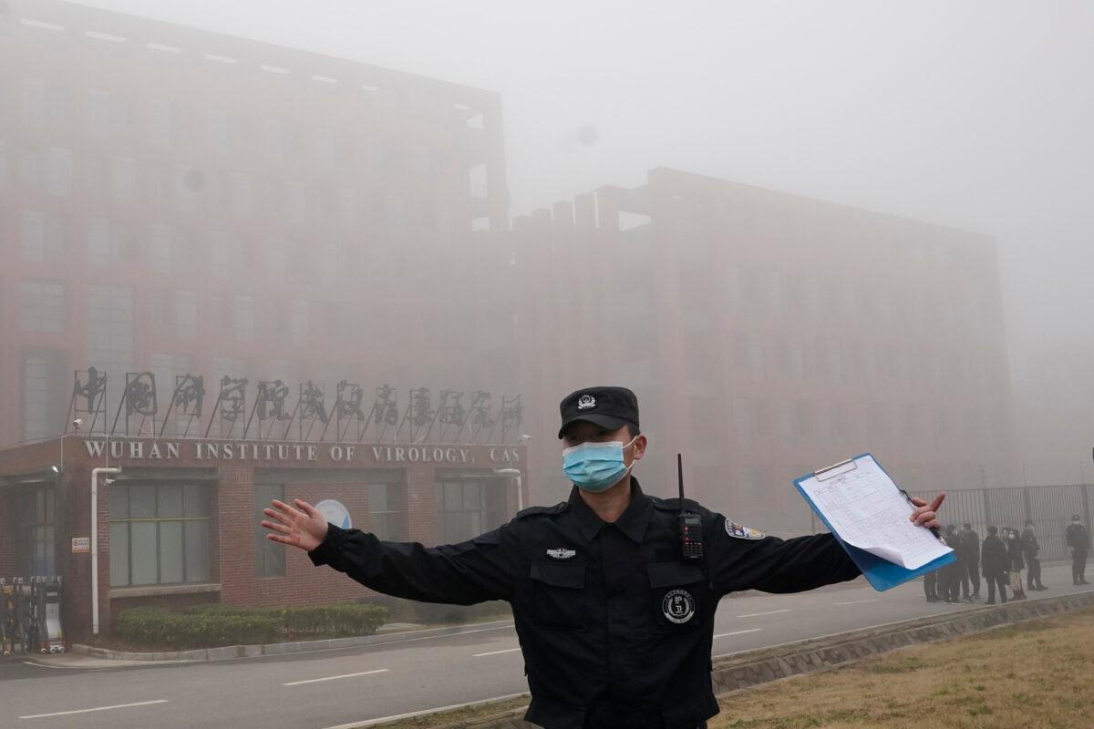 A security person moves journalists away from the Wuhan Institute of Virology after a World Health Organization team arrived for a field visit in Wuhan in China's Hubei province, China, on Feb. 3, 2021. (Ng Han Guan/AP Photo)
