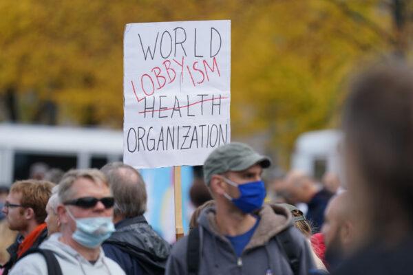 Protesters, including one holding a sign denigrating the World Health Organization, march to the Kosmos events venue where the World Health Summit was originally scheduled to take place on October 25, 2020 in Berlin, Germany. (Sean Gallup/Getty Images)