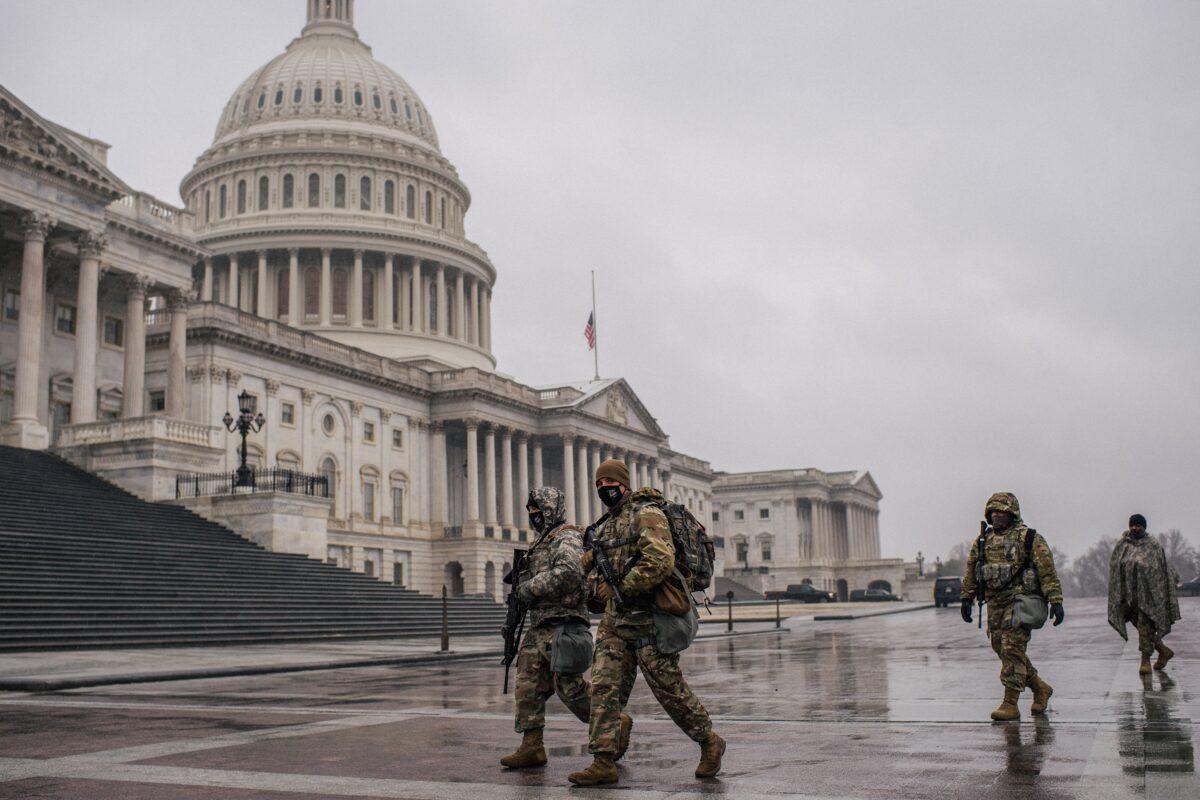 Members of the National Guard walk through U.S. Capitol grounds in Washington on Feb. 13, 2021. (Brandon Bell/Getty Images)