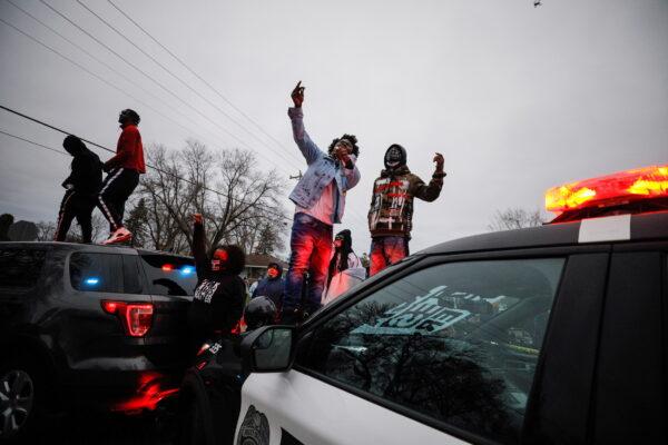 Demonstrators stand on a police vehicle during a protest after police shot and killed a man, Daunte Wright, in Brooklyn Center, Minnesota, on April 11, 2021. (Nick Pfosi/Reuters)