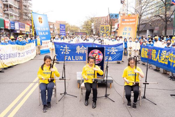 Chen Fayuan (C), a 16-year-old Erhu player, at a rally in Flushing, New York, on April 18, 2021, to commemorate the 22nd anniversary of the April 25th peaceful appeal of 10,000 Falun Gong practitioners in Beijing. (Larry Dye/The Epoch Times)