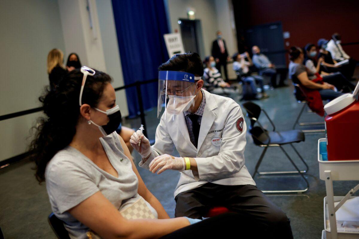 A woman receives a dose of the Johnson & Johnson COVID-19 vaccine at a vaccination center in Chinatown in Chicago on April 6, 2021. (Carlos Barria/Reuters)
