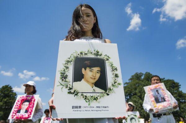 Falun Gong practitioners hold memorial pictures at Capitol Hill in Washington, on July 17, 2014. (Jim Watson/AFP/Getty Images)