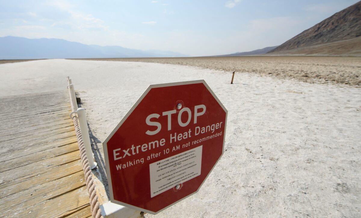 Signage warns of extreme heat danger at the salt flats of Badwater Basin inside Death Valley National Park, in Inyo County, Calif., on June 17, 2021. (Patrick T. Fallon/AFP via Getty Images)