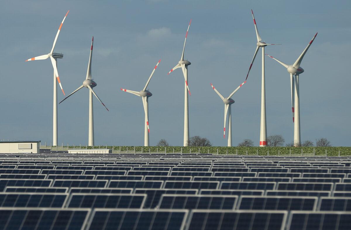 Wind turbines stand behind a solar power park near Werder, Germany on Oct. 30, 2013. (Sean Gallup/Getty Images)