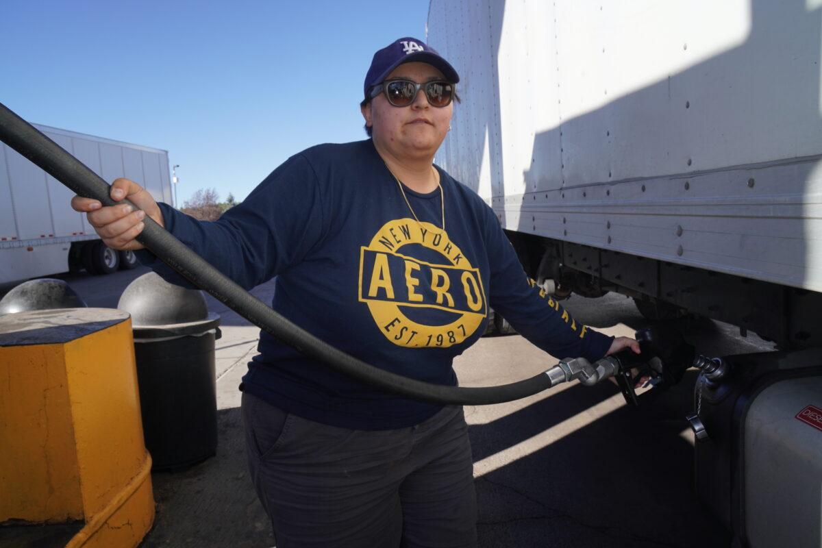 CGS Transport truck driver Vivian Alexis fills a fuel tank at Pilot Travel Center truck stop in Bellemont, Ariz., on Oct. 19. Alexis said many truck drivers she’s spoken with oppose the federal vaccine mandate for COVID-19. (Allan Stein/The Epoch Times)