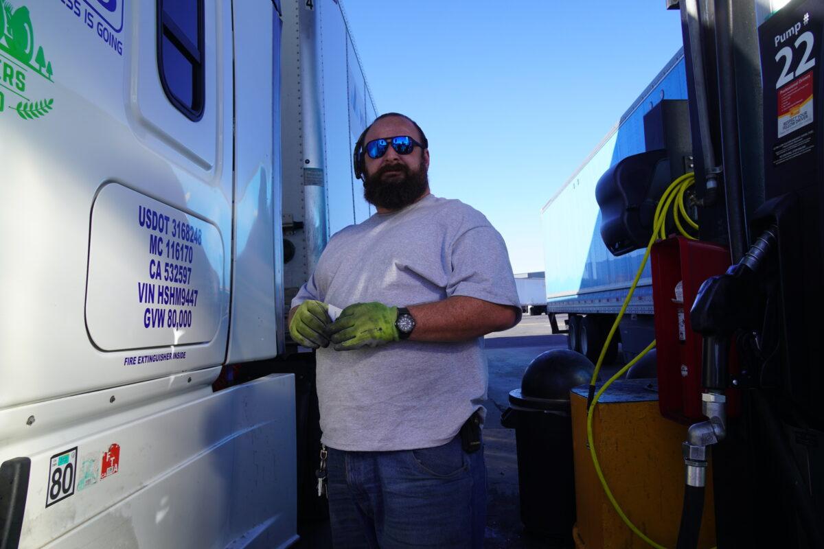 Capital City Cargo truck driver Robert Wagner finishes filling up his big rig at Pilot Travel Center in Bellemont, Ariz., on Oct. 19. Wagner said that many long-distance truck drivers like him reject federal vaccine mandates for COVID-19. “It’s poison, man,” he said of the vaccines. (Allan Stein/The Epoch Times)