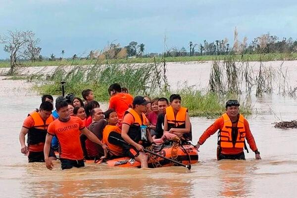 Rescuers pull a rubber boat as they assist residents who were trapped in their homes after floodwaters caused by Typhoon Rai inundated their village in Negros Occidental, central Philippines, on Dec. 17, 2021. (Philippine Coast Guard via AP)