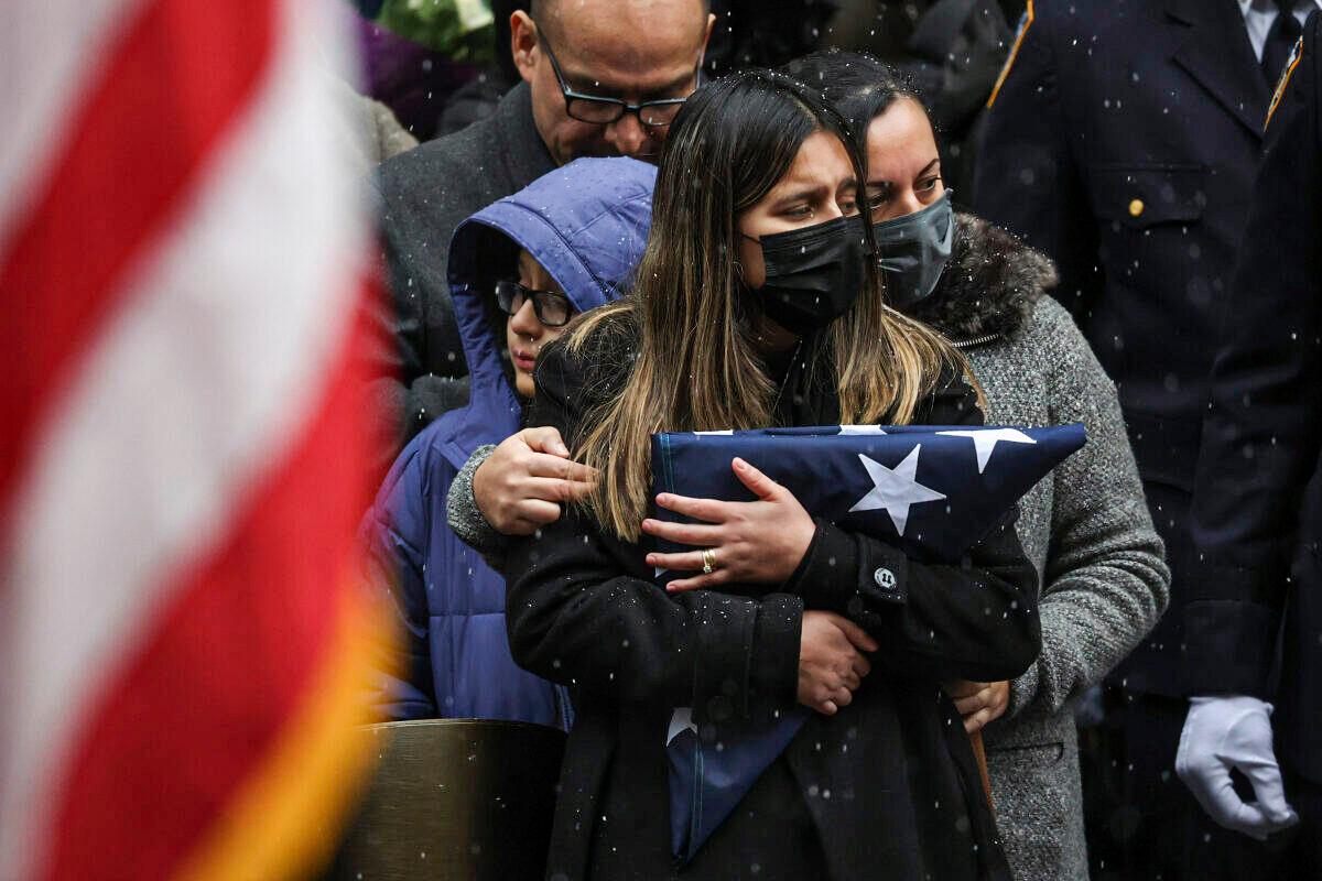 Dominique Rivera (L), wife of NYPD Officer Jason Rivera, watches as his casket is loaded into a hearse outside St. Patrick's Cathedral after his funeral service in New York on Jan. 28, 2022. Rivera was killed while responding to a domestic disturbance call. (Yuki Iwamura/AP Photo)