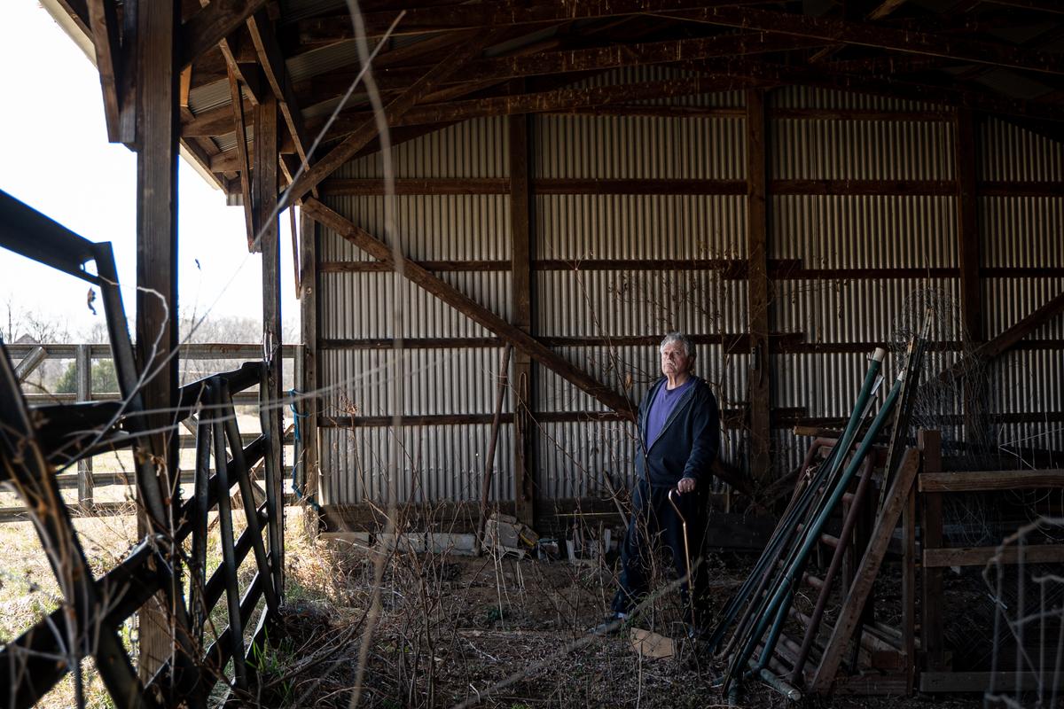 Thomas Caldwell inside an empty barn that used to hold farming equipment, after selling the animals and equipment to pay legal bills, in Berryville, Va., on March 19, 2022. (Samira Bouaou/The Epoch Times)