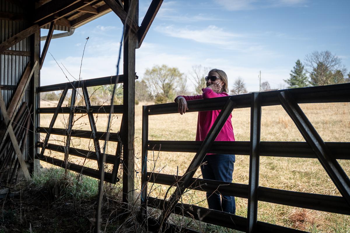 Sharon Caldwell outside an empty barn that used to hold farming equipment, after selling the animals and equipment to pay legal bills, in Berryville, Va., on March 19, 2022. (Samira Bouaou/The Epoch Times)