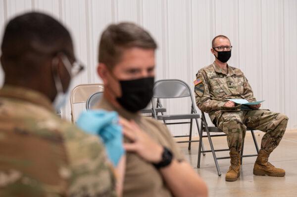 A soldier watches another soldier receive his COVID-19 vaccination in Fort Knox, Ky., on Sept. 9, 2021. (Jon Cherry/Getty Images)