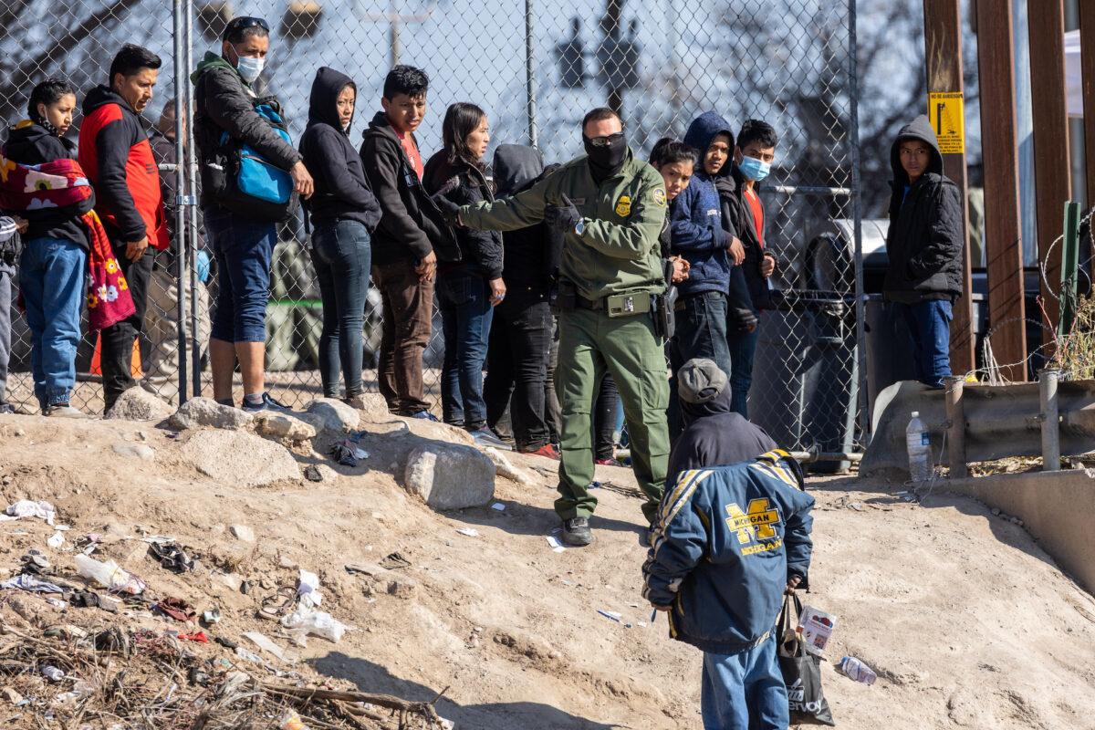 A U.S. Border Patrol agent instructs immigrants who had crossed the Rio Grande into El Paso, Texas, as seen from Ciudad Juarez, Mexico, on Dec. 19, 2022. (John Moore/Getty Images)