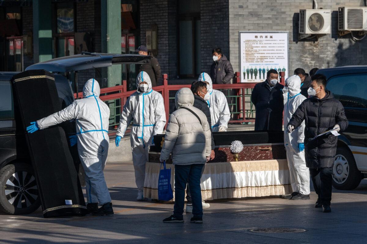 Workers in protective gear handle a coffin and coffin case at Dongjiao Funeral Parlor, reportedly designated to handle COVID-19 fatalities, in Beijing on Dec. 19, 2022. (Bloomberg)