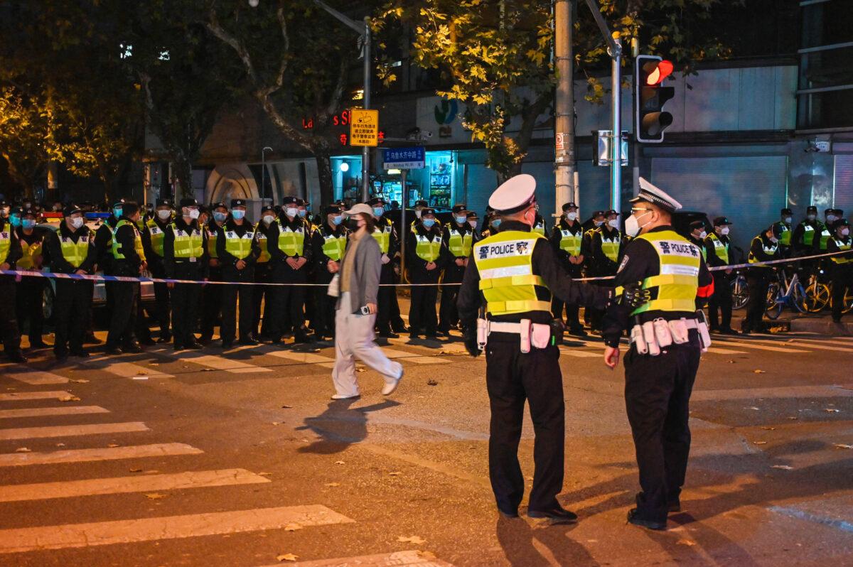 Police officers block Wulumuqi Street in Shanghai where protests were held against zero-COVID the previous night in response to a deadly fire in Unumqi, Xinjiang, on Nov. 27, 2022, where protests against zero-COVID took place the previous night in response to a deadly fire in Urumqi, Xinjiang. (Hector Retamal/AFP via Getty Images)