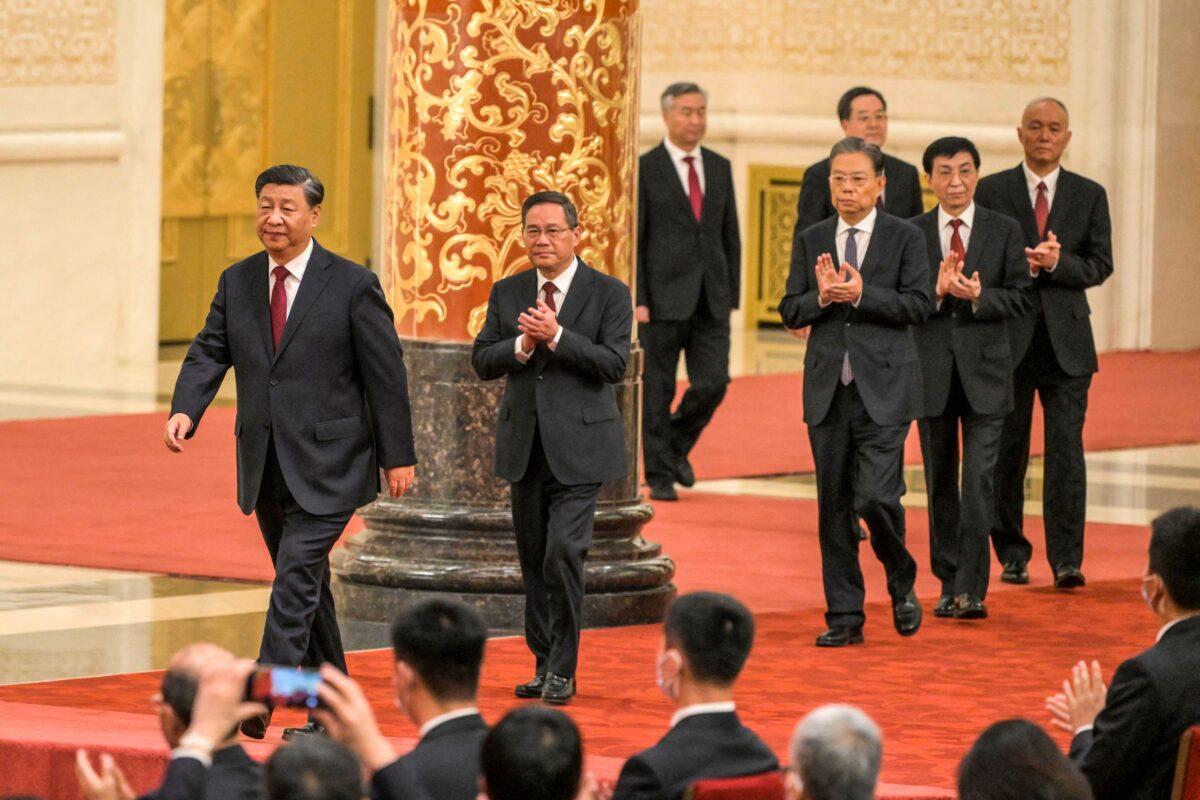 China's President Xi Jinping (L) walks with (2nd L to R) Li Qiang, Li Xi, Zhao Leji, Ding Xuexiang, Wang Huning, and Cai Qi, members of the Chinese Communist Party's new Politburo Standing Committee, the nation's top decision-making body, as they meet the media in the Great Hall of the People in Beijing on Oct. 23, 2022. (Wang Zhao/AFP via Getty Images)