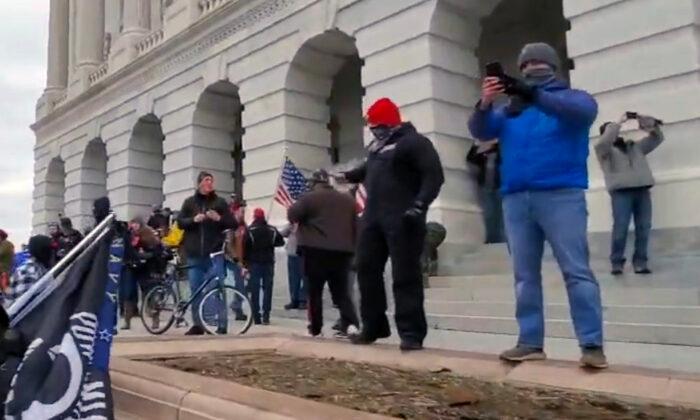 Two undercover Metropolitan Police Department officers (in red and gray caps) outside the U.S. Capitol in Washington on Jan. 6, 2021. (Archive.org/Screenshot via The Epoch Times)