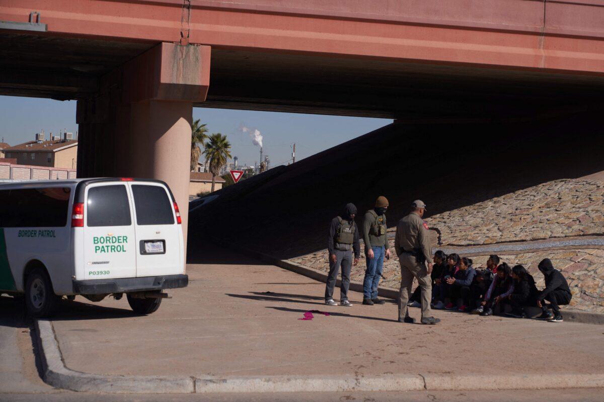 Would-be illegal immigrants wait to be processed by U.S. Border Patrol after crossing into the United States from Mexico via a hole cut in the border fence in El Paso, Texas, on Dec. 21, 2022. (Allison Dinner/AFP/Getty Images)