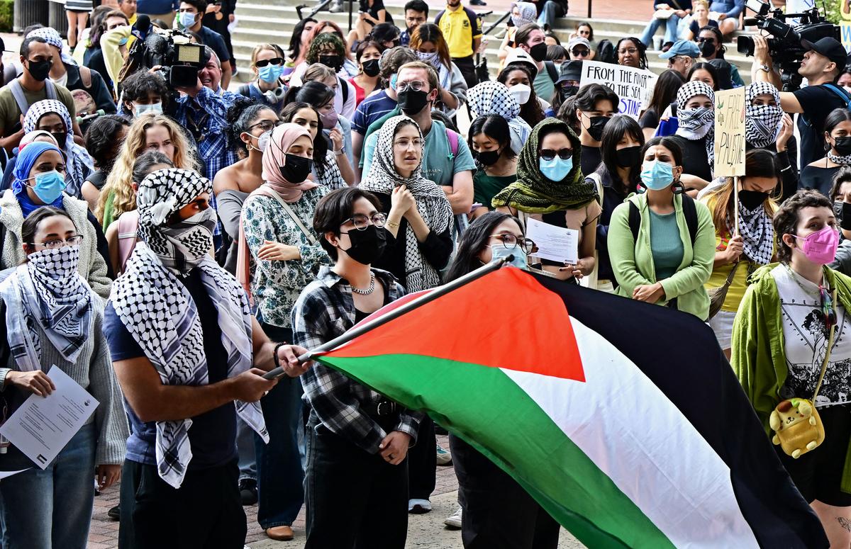 A person holds a Palestinian flag as students participate in a "Walkout to fight Genocide and Free Palestine" at Bruin Plaza at the University of California–Los Angeles on Oct. 25, 2023. (Frederic J. Brown/AFP via Getty Images)