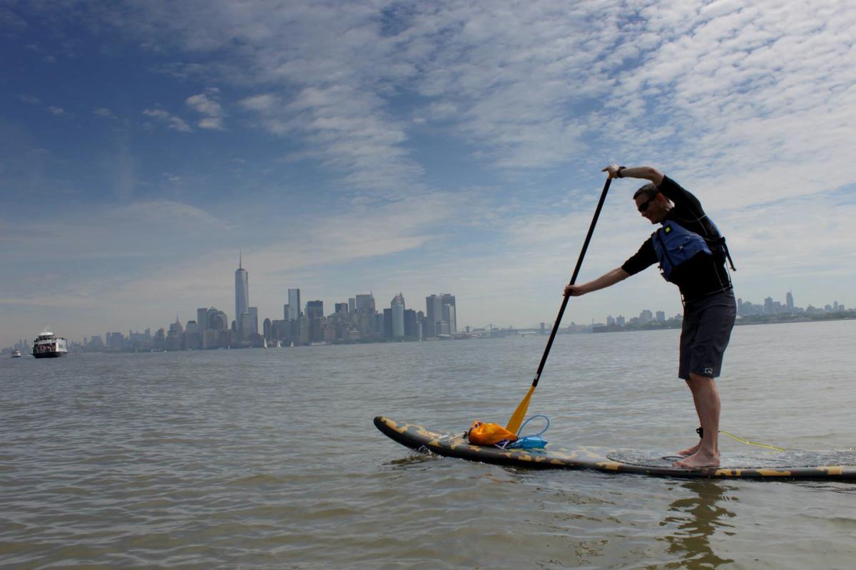 Stand-up paddle boarding offers a unique way to explore the city's waterways while enjoying a full-body workout and connecting with nature. (Courtesy of Manhattan Kayak Co.)