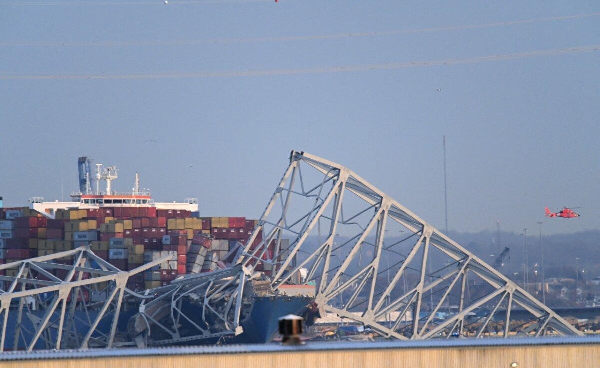 The steel frame of the Francis Scott Key Bridge sit on top of a container ship after the bridge collapsed collapsed in Baltimore, Maryland, on March 26, 2024. (Mandel Ngan/AFP via Getty Images)