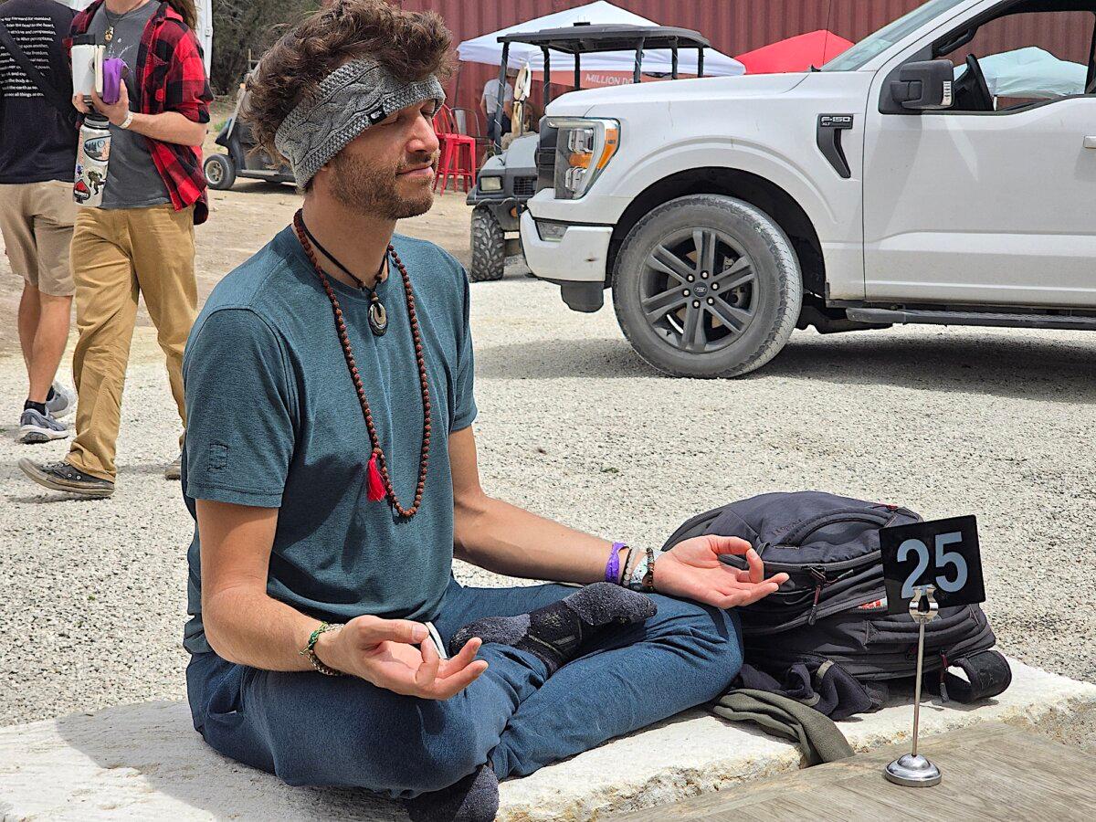 A visitor takes a moment for meditation during Confluence 2024 at Sovereign Ranch in Bandera, Texas, on April 5, 2024. (Allan Stein/The Epoch Times)